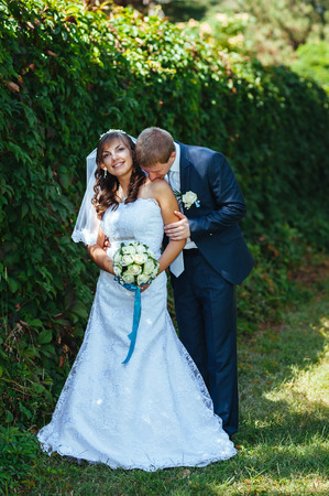 Bride and Groom at wedding Day walking Outdoors on spring nature. Bridal couple, Happy Newlywed woman and man embracing in green park. Loving wedding couple outdoor.の写真素材