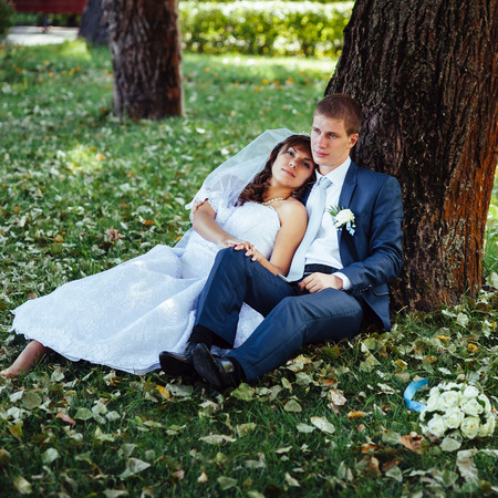 Bride and Groom at wedding Day walking Outdoors on spring nature. Bridal couple, Happy Newlywed woman and man embracing in green park. Loving wedding couple outdoor.の写真素材