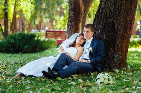 Bride and Groom at wedding Day walking Outdoors on spring nature. Bridal couple, Happy Newlywed woman and man embracing in green park. Loving wedding couple outdoor.の写真素材