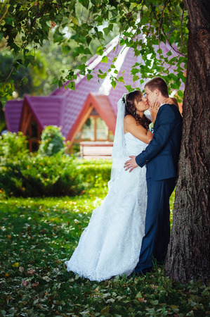 Bride and Groom at wedding Day walking Outdoors on spring nature. Bridal couple, Happy Newlywed woman and man embracing in green park. Loving wedding couple outdoor.の写真素材