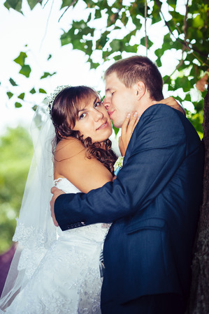 Bride and Groom at wedding Day walking Outdoors on spring nature. Bridal couple, Happy Newlywed woman and man embracing in green park. Loving wedding couple outdoor.の写真素材