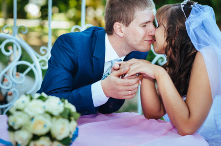 Bride and groom posing at the decorated banquet table in the park in the summer. Enjoy a moment of happiness and love. A series of photos in my portfolio.の写真素材