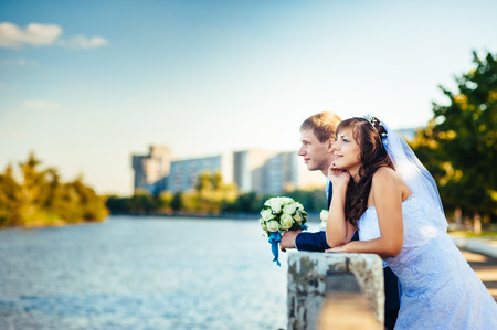 Bride and Groom at wedding Day walking Outdoors on spring nature. Bridal couple, Happy Newlywed woman and man embracing in green park. Loving wedding couple outdoor.の写真素材