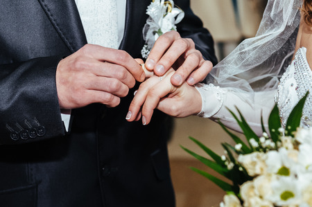 Wedding ceremony. Registry office. A newly-married couple signs the marriage document. Young couple signing wedding documents.の写真素材