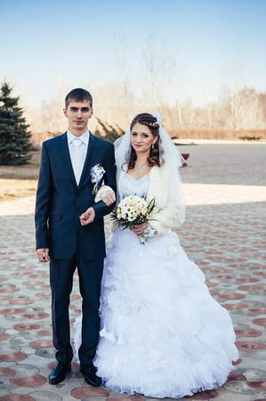 Elegant bride and groom posing together outdoors on a wedding day.の写真素材
