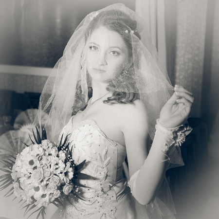 Portrait beautiful bride with bouquet of flowers on luxury interior in wedding day.の写真素材
