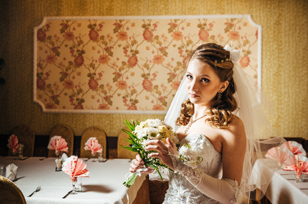 Portrait beautiful bride with bouquet of flowers on luxury interior in wedding day.の写真素材