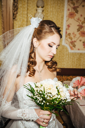 Portrait beautiful bride with bouquet of flowers on luxury interior in wedding day.の写真素材