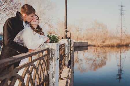 A wedding by the sea. Honeymoon. The bride and groom hugging on the shore of Lake. groom and bride hugging on a green lake. Groom and Bride in a park. wedding dress. Bridal wedding bouquet of flowersの写真素材
