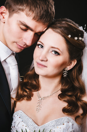 Bride and groom kissing and hugging. wedding photo taken in the studio on a black background.の写真素材