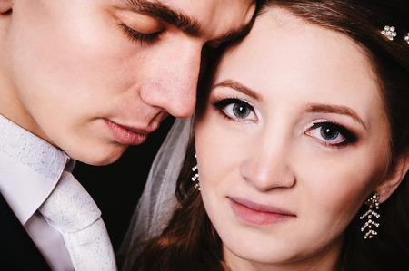 Bride and groom kissing and hugging. wedding photo taken in the studio on a black background.の写真素材