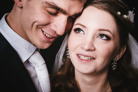 Bride and groom kissing and hugging. wedding photo taken in the studio on a black background.の写真素材