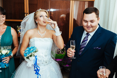 bride and groom holding beautifully decorated wedding glasses with champaigne.の写真素材