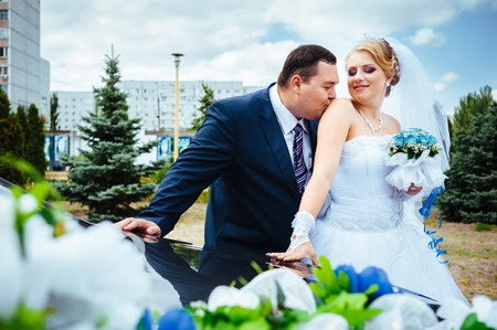 Happy groom helping his bride out of the wedding carの写真素材