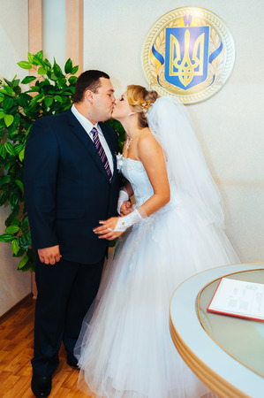 Wedding ceremony. Registry office. A newly-married couple signs the marriage document.Young couple signing wedding documents.の写真素材