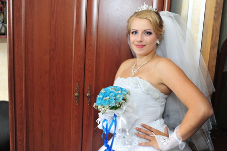 Young beautiful bride with bouquet in handsの写真素材