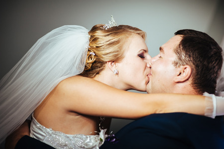 Charming bride and groom on their wedding celebration in a luxurious restaurant. Wedding bouquet of flowers and bridal dress. newly married couple in luxury modern hotel hall.の写真素材