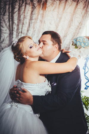 Charming bride and groom on their wedding celebration in a luxurious restaurant. Wedding bouquet of flowers and bridal dress. newly married couple in luxury modern hotel hall.の写真素材