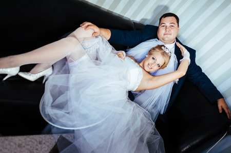 Charming bride and groom on their wedding celebration in a luxurious restaurant. Wedding bouquet of flowers and bridal dress. newly married couple in luxury modern hotel hall.の写真素材