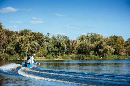 Newly married couple riding in boat on river.の写真素材