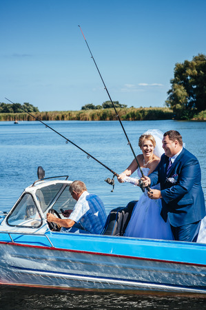 Newly married couple riding in boat on river.の写真素材
