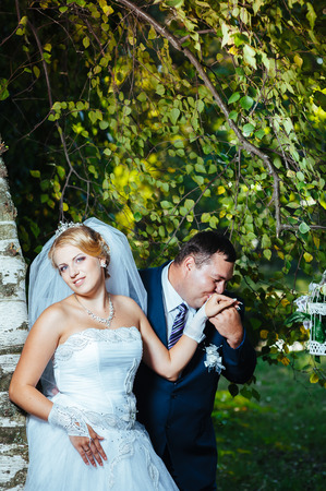 Bride and groom at wedding Day walking Outdoors on spring nature. Bridal couple, Happy Newlywed woman and man embracing in green park. Loving wedding couple outdoor. Bride and groom.の写真素材