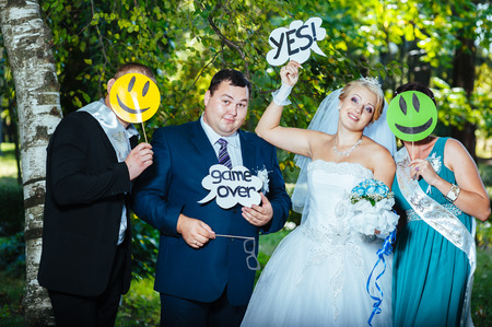 portrait of newlywed couple dancing and having fun with bridesmaids and groomsmen in green sunny park.の写真素材