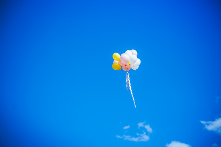 multicolored festival Colorful balloons in flight. Bunch of colorful balloons in blue skyの写真素材