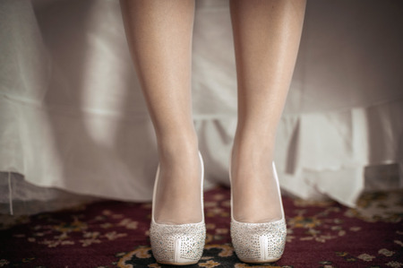 Bride is putting on her wedding shoes. の写真素材
