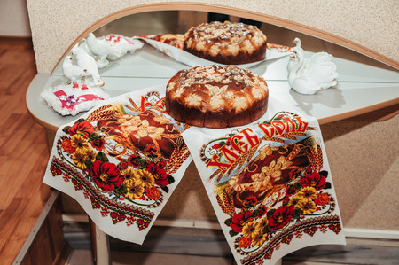 Wedding bread from wheat flour dough decorated with flowers - traditional Ukrainian round loaf an embroidery towelの写真素材