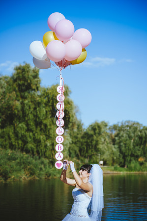 Happy young girl with big colorful latex balloons. の写真素材