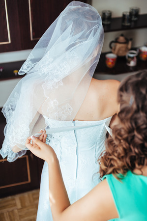 Bride getting ready. beautiful bride in white wedding dress with hairstyle and bright makeup. Happy sexy girl waiting for groom. Romantic lady in bridal dress have final preparation for wedding.の写真素材