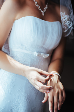 Bride getting ready. beautiful bride in white wedding dress with hairstyle and bright makeup. Happy sexy girl waiting for groom. Romantic lady in bridal dress have final preparation for wedding.の写真素材