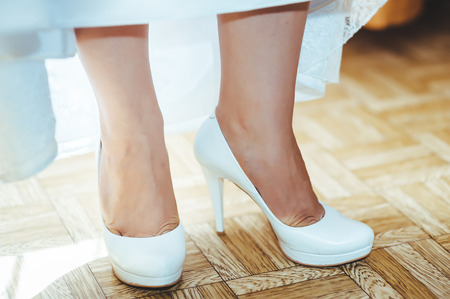 Bride getting ready. beautiful bride in white wedding dress with hairstyle and bright makeup. Happy sexy girl waiting for groom. Romantic lady in bridal dress have final preparation for wedding.の写真素材