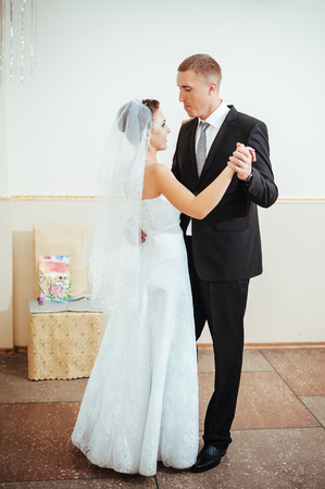 beautiful caucasian couple just married and dancing their first dance.の写真素材
