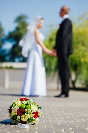 Bride and Groom at wedding Day walking Outdoors on spring nature. Bridal couple, Happy Newlywed woman and man embracing in green park. Loving wedding couple outdoor. Wedding shot of bride and groom in parkの写真素材
