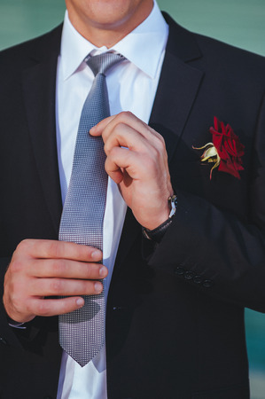 Portrait of handsome groom in the park getting ready for the weddingの写真素材