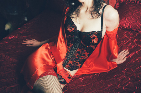 Sexy slim brunette woman posing in bed. Lady wearing sensual lingerieの写真素材