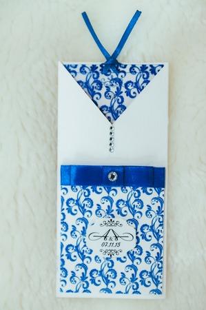 Closeup shot of Wedding invitations and golden rings.