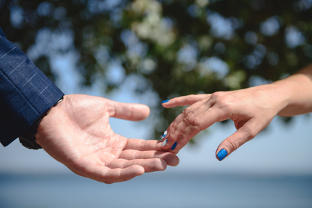 Young married couple holding hands, ceremony wedding day.の写真素材