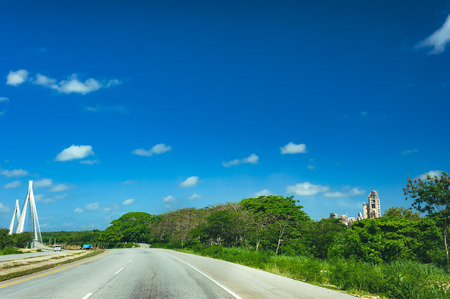 Road crossing the forest with cloudy sky and mountain view.の写真素材