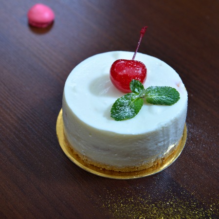 Cheesecake with sour cherry and mint leaf on wooden background. cupcakes with decorations for...
