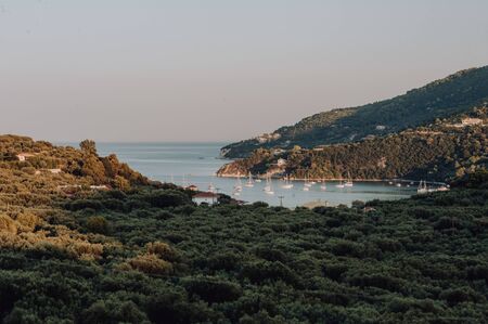 Peaceful beach with golden island and sand at sunset, sea with calm water, Greeceの写真素材