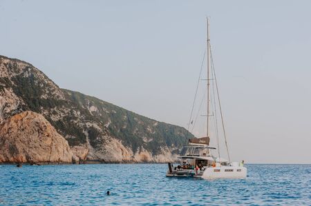 Sailing yaht in open sea on beautiful sunset sky background