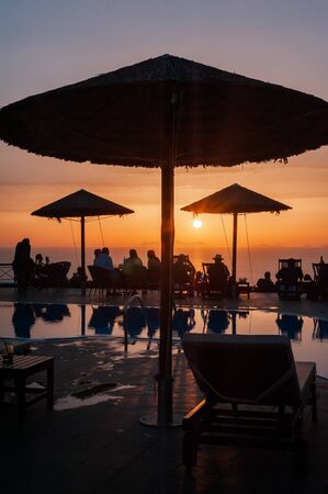 Santorini, Greece - May 20, 2019: some people doing happy hour during sunset in Oia