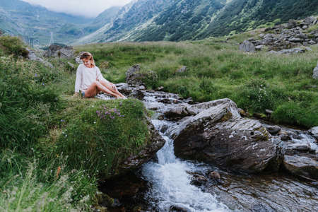 Relaxing concept, Woman sitting nearby waterfall. Film toneの写真素材