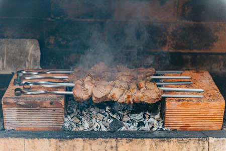 closeup of some meat skewers being grilled in a barbecueの写真素材