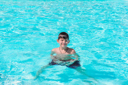 Activities on the pool, children swimming and playing in water, happiness and summertime. Young Boy Fun in the Swimming Pool with Goggles. Summer Vacation Fun.の写真素材