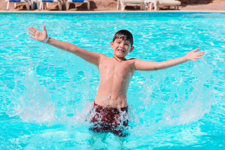 Activities on the pool, children swimming and playing in water, happiness and summertime. Young Boy Fun in the Swimming Pool with Goggles. Summer Vacation Fun.の写真素材