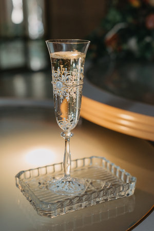 A WEDDING GLASS OF CHAMPAGNE STANDS ON THE TABLE IN A CRYSTAL PLATEの写真素材